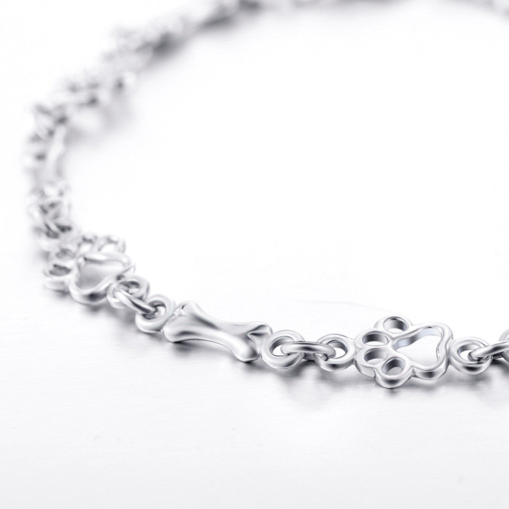Pulsera edición limitada con colgantes de plata maciza en forma de pata de perro y hueso