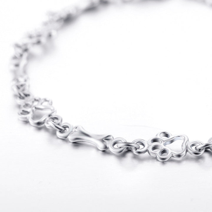 Pulsera edición limitada con colgantes de plata maciza en forma de pata de perro y hueso
