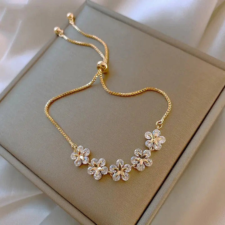 Pulsera dorada con margaritas y cristales